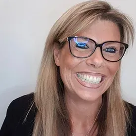 Smiling woman with glasses and long blonde hair