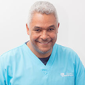Smiling male healthcare professional in light blue scrubs