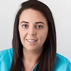 Smiling young woman with dark hair in blue scrubs