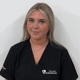 Female healthcare professional in black Secrets Medical Centre scrubs