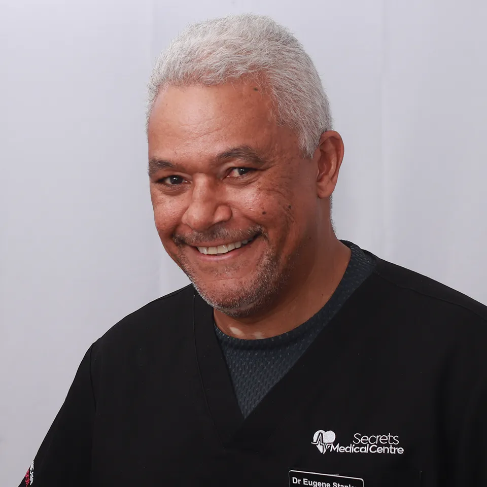 Dr. Eugene Stanley smiling in black medical scrubs