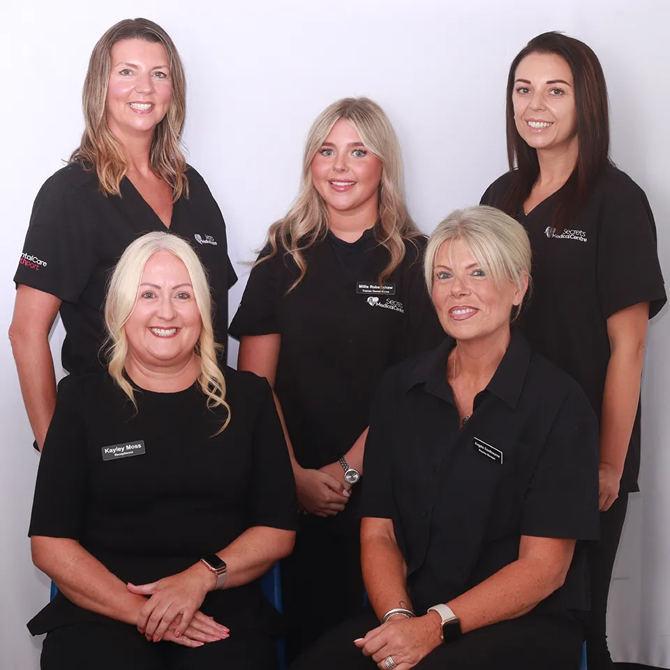 Five female medical center staff members in black uniforms