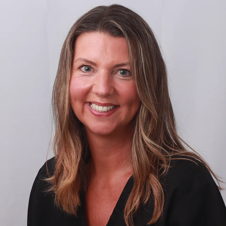 Smiling woman with long brown hair in professional headshot