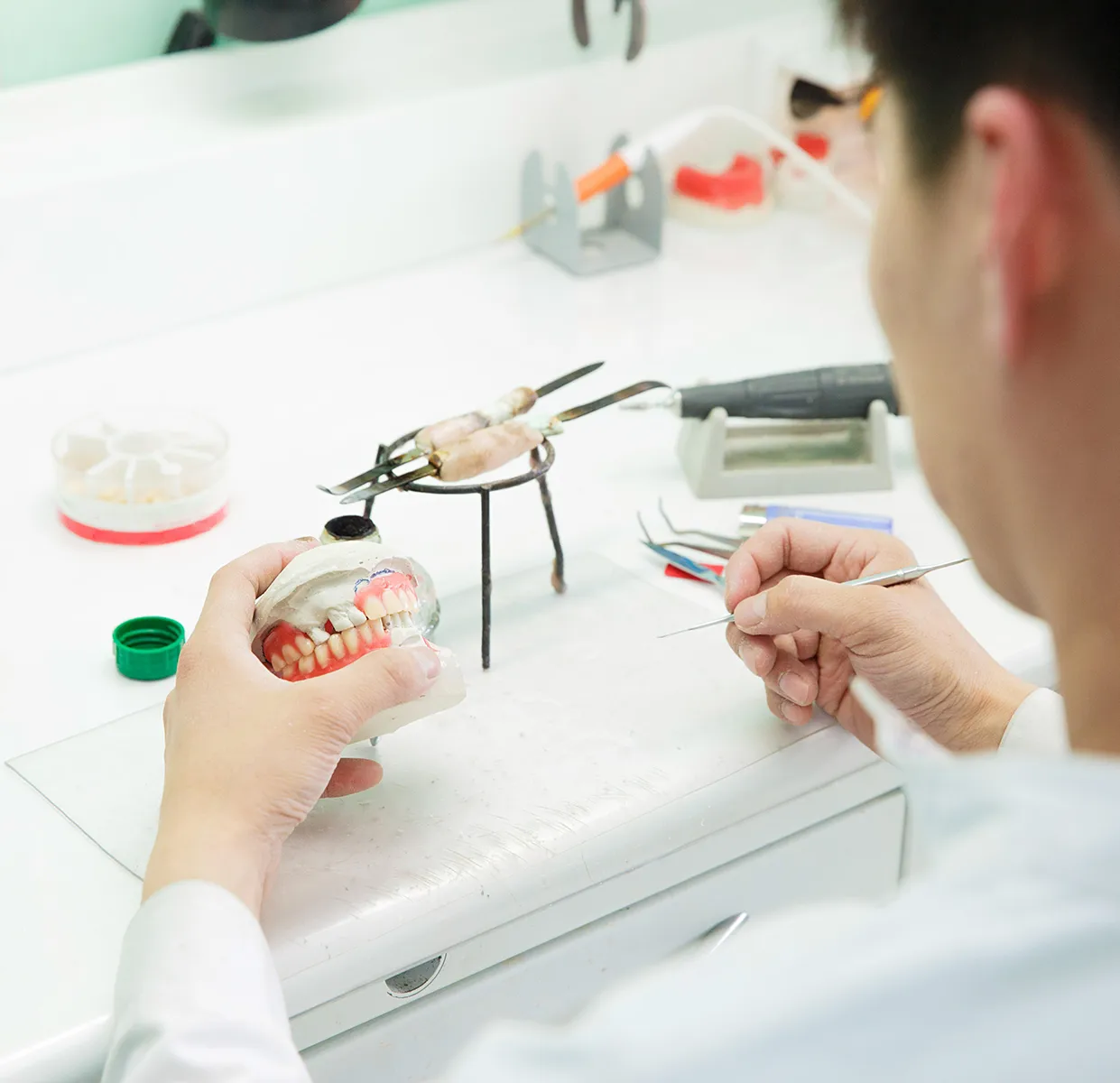 Dental technician crafting dentures in a laboratory